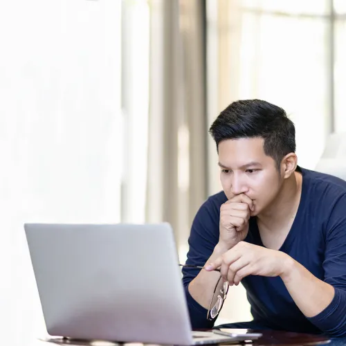 Man stares intently at his laptop as he researches which co-parenting app to choose.