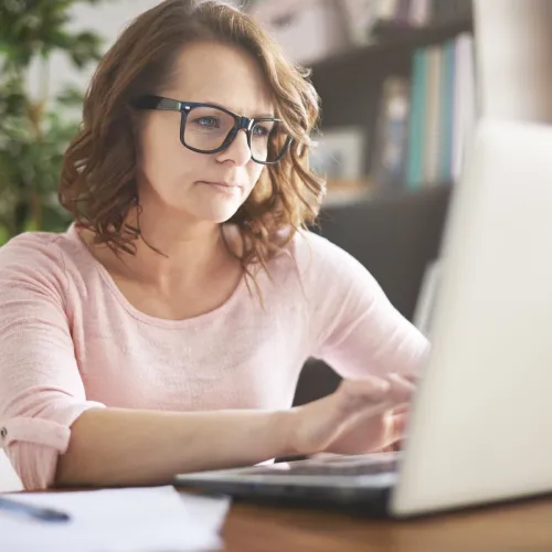 Woman works on her computer at her desk. 