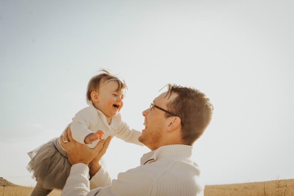 Father holding laughing baby daughter