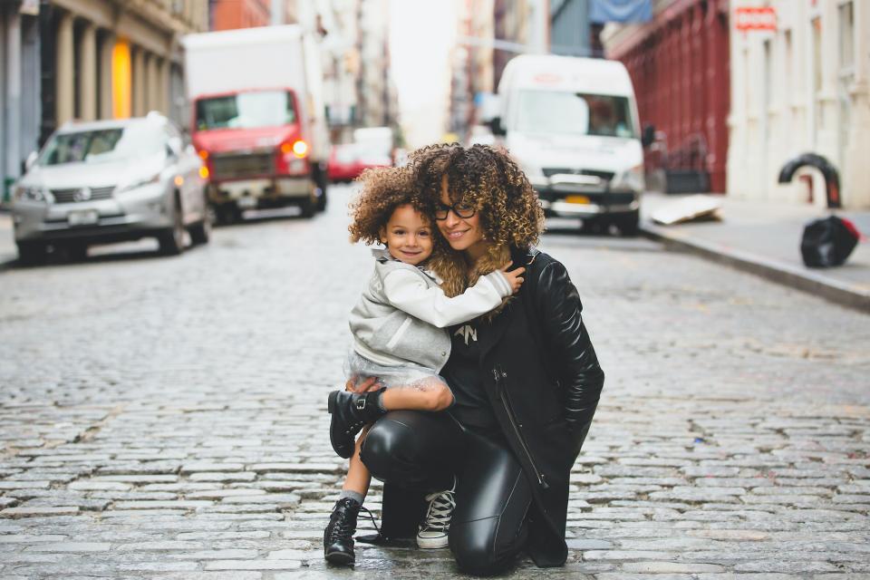 woman and daughter in street posing for a photo